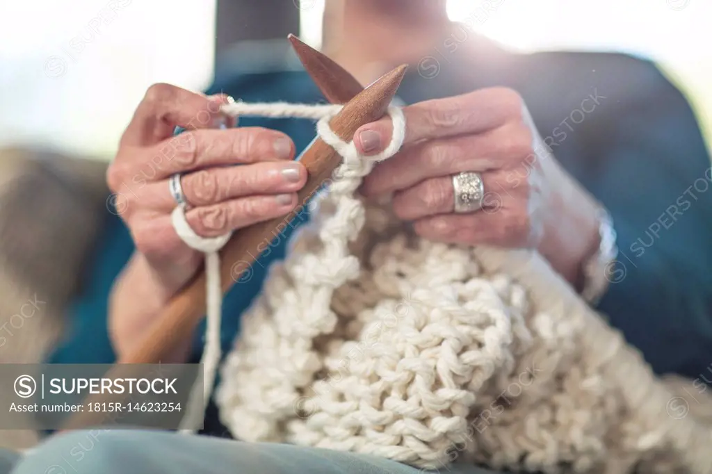 Senior woman knitting on couch at home