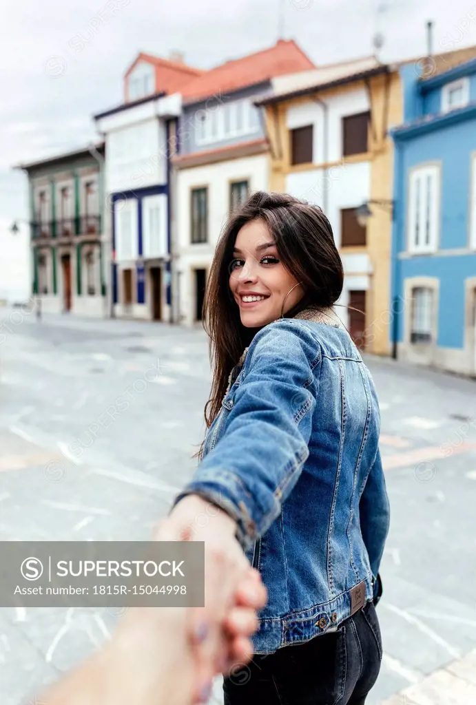 Portrait of a smiling brunette woman holding hand in a town