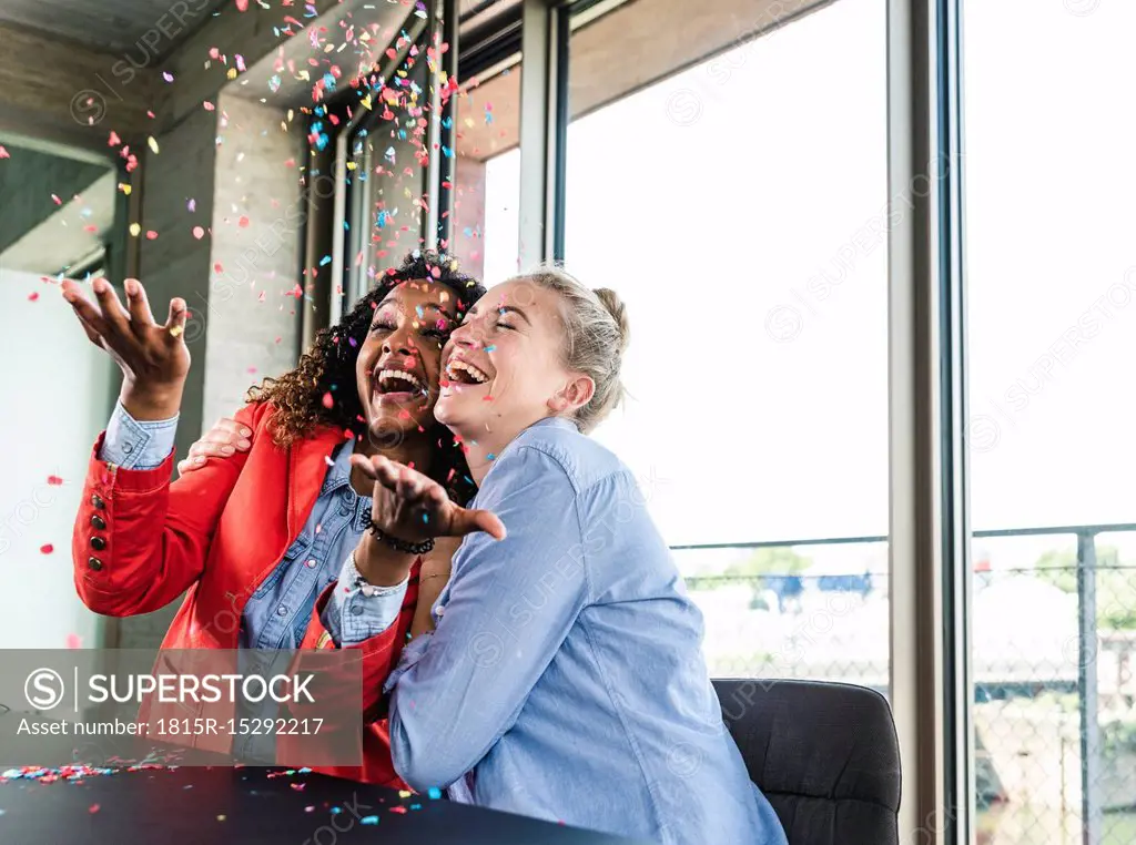 Young busniesswomen celebrating success, throwing confetti