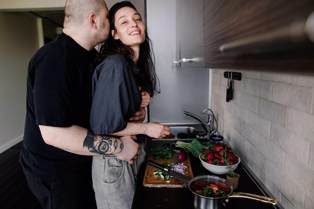 Man hugging and kissing woman in the kitchen