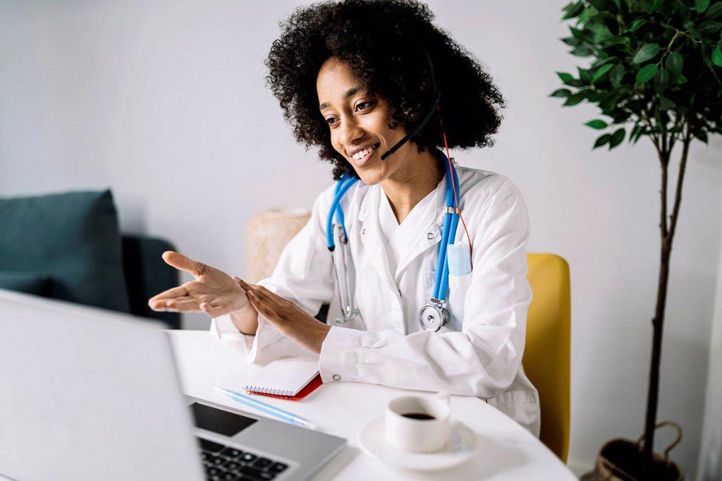 Female medical professional doing online consulation on laptop at home