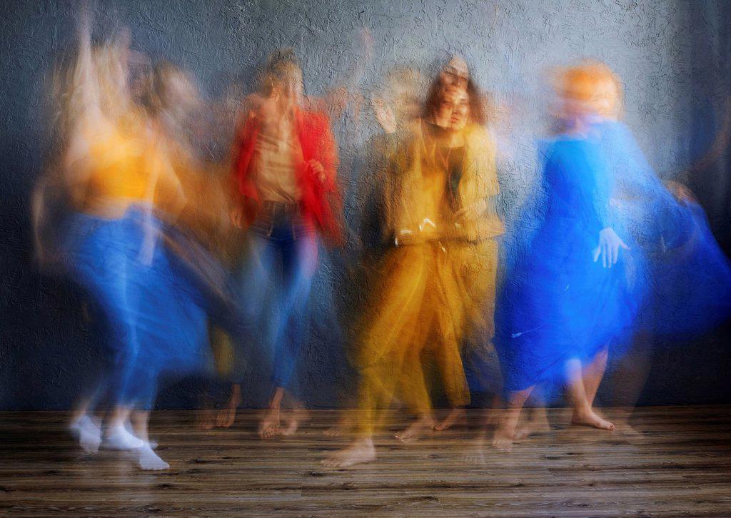Women in multi colored dress dancing on floor in studio