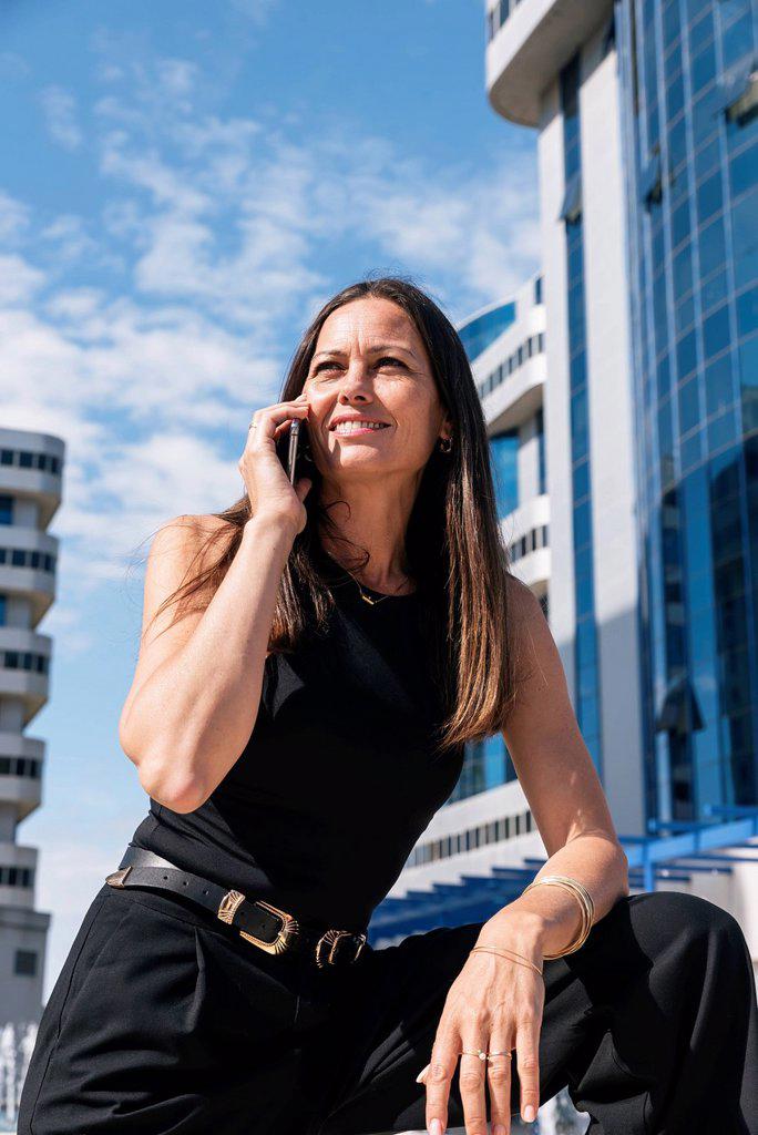 Businesswoman talking on mobile phone during sunny day