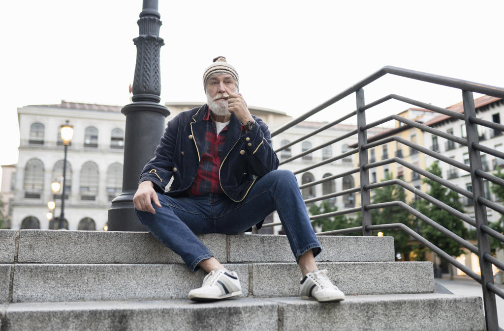 Mature man looking away while smoking pipe on steps