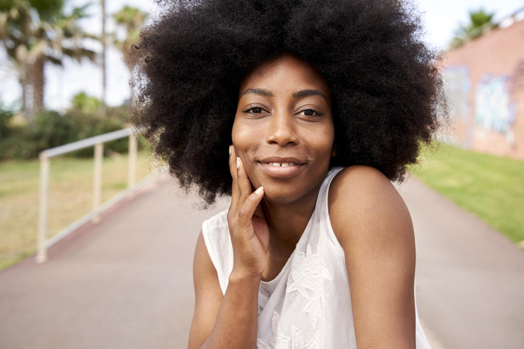 Afro young woman smiling on road