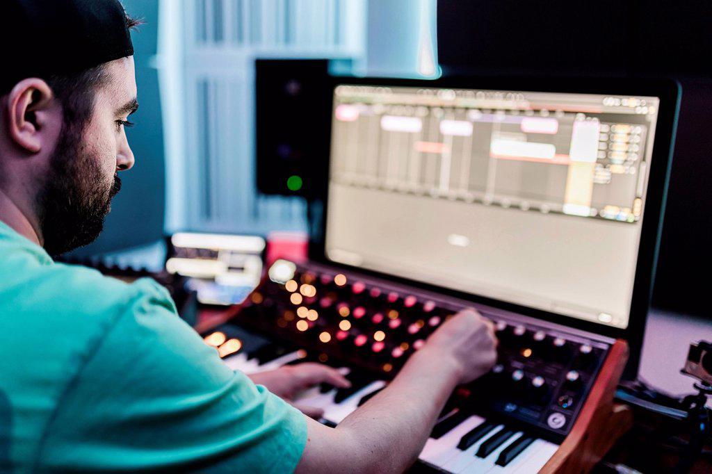 Male composer mixing sound in studio