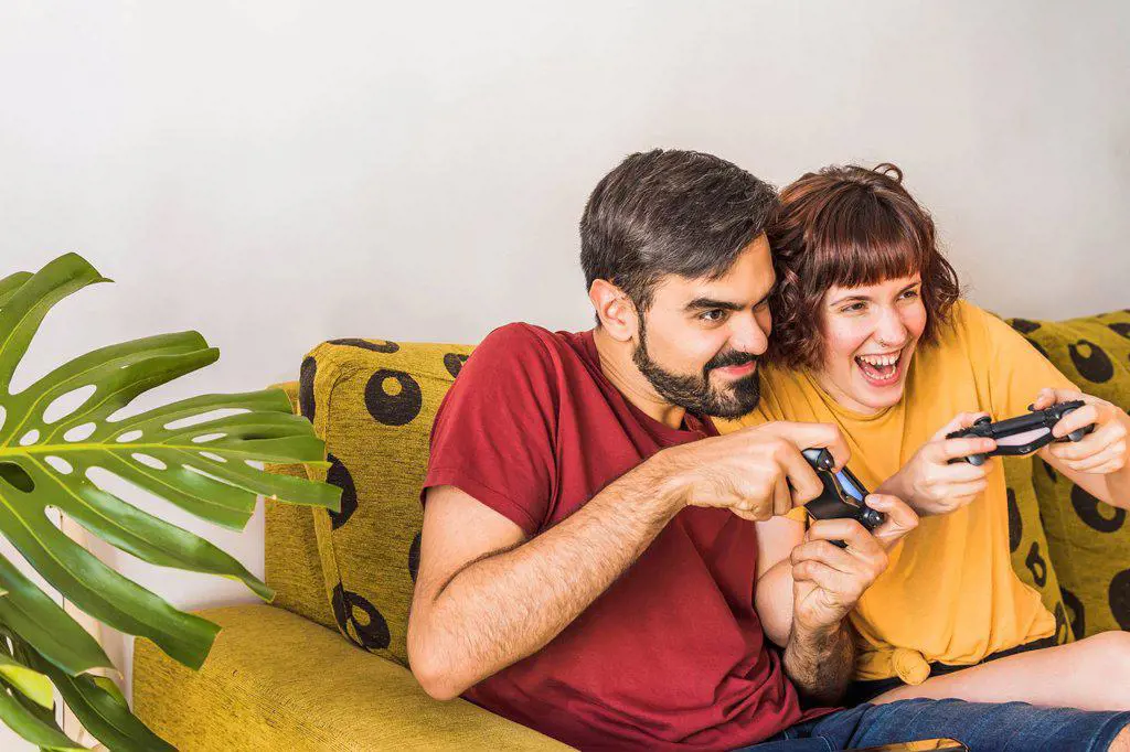 Cheerful couple playing video game at home