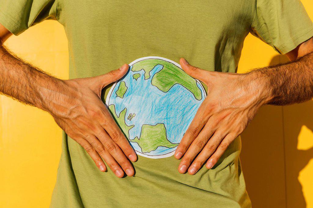 Man holding planet earth drawing during sunny day