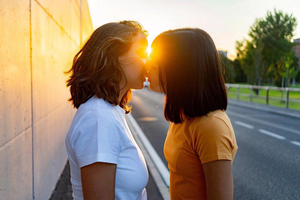Young lesbian couple kissing during sunset
