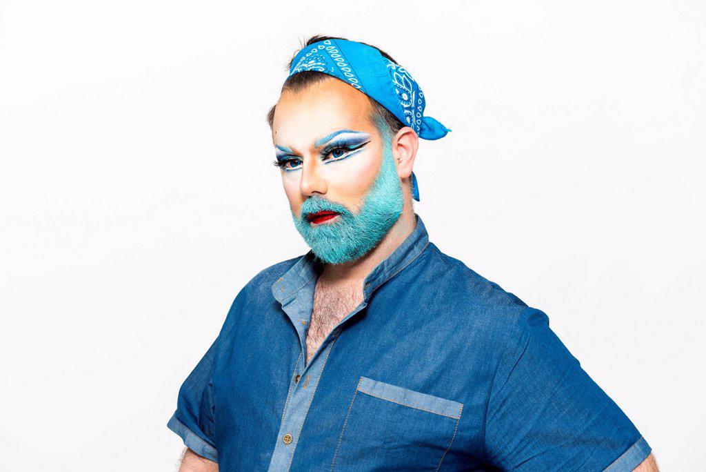 Man with blue beard and make-up against white background