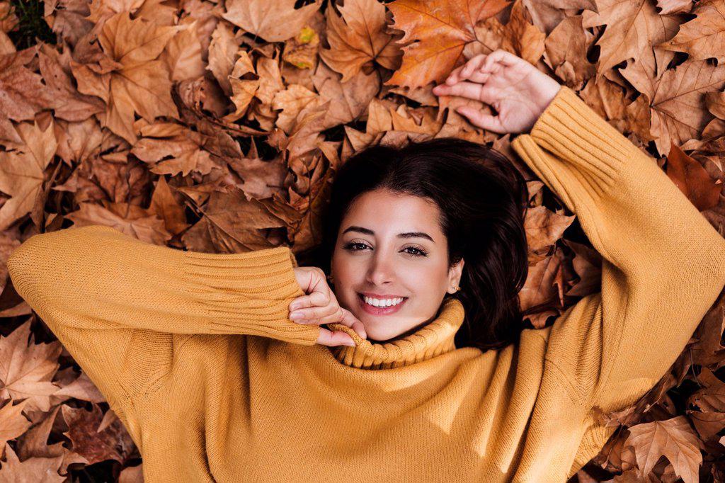 Young woman resting on maple leaves