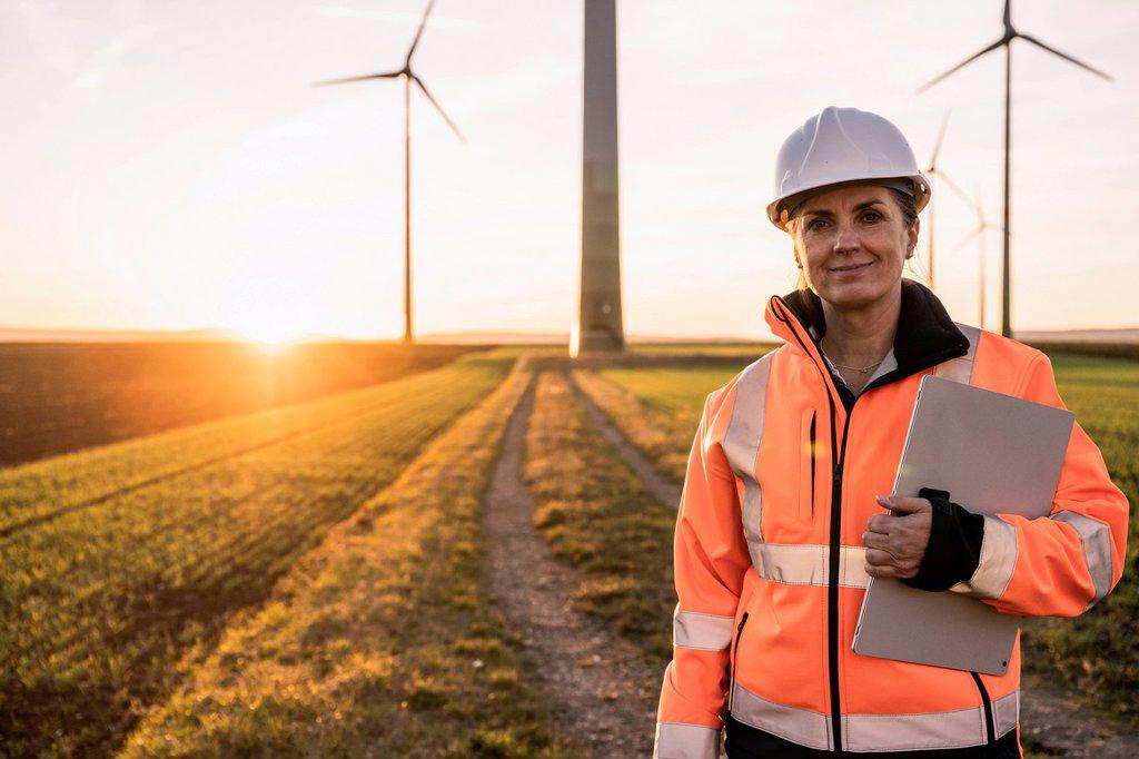 Smiling engineer with digital tablet at wind park