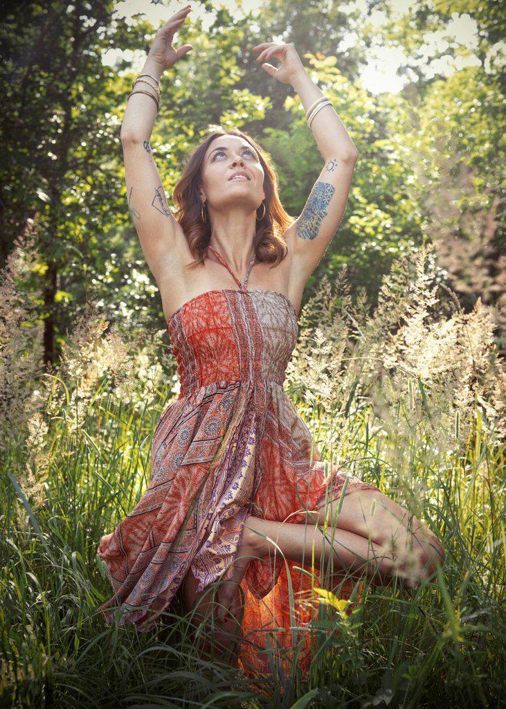 Woman practicing yoga amidst plants in forest