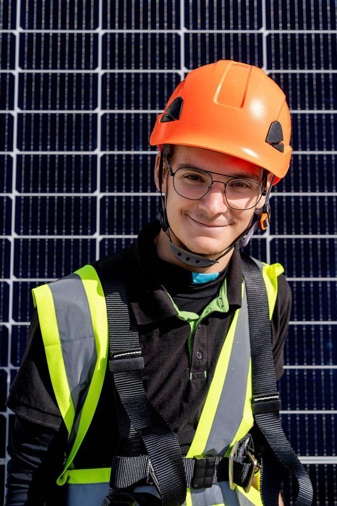 Smiling technician with helmet on sunny day