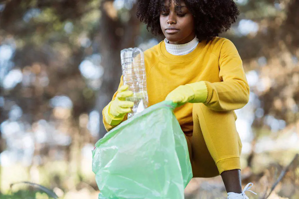 Volunteer collecting plastic garbage in public park