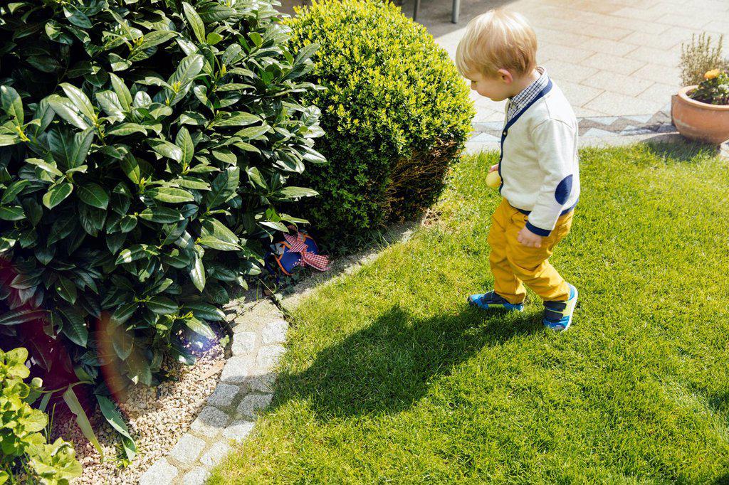 Little boy finding an Easter surprise in the garden