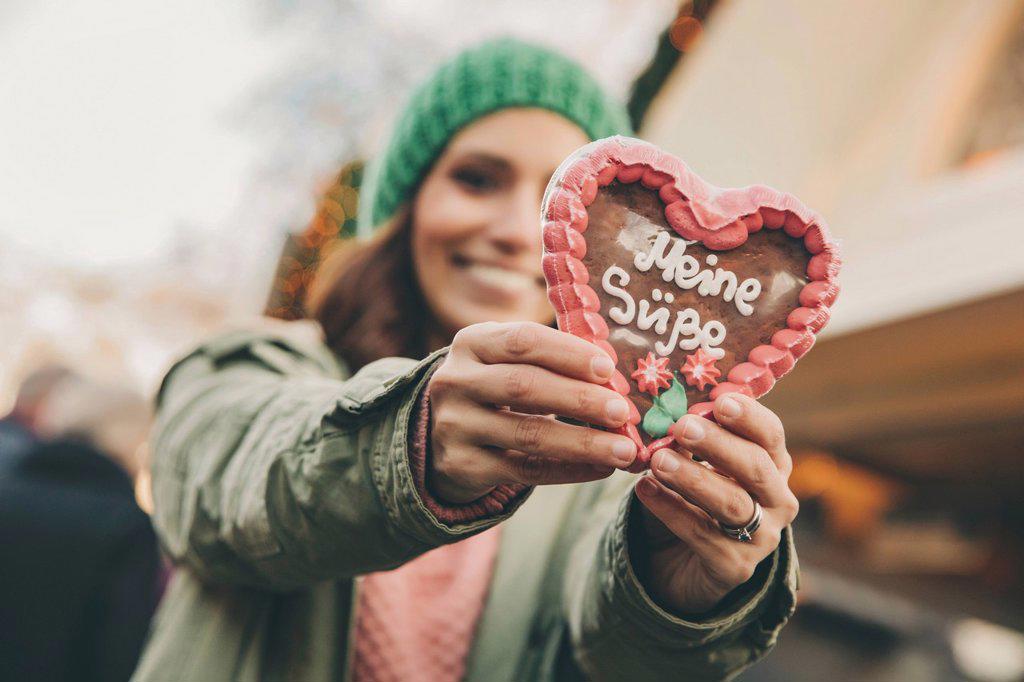 Woman holding up a gingerbread heart on the Christmas Market