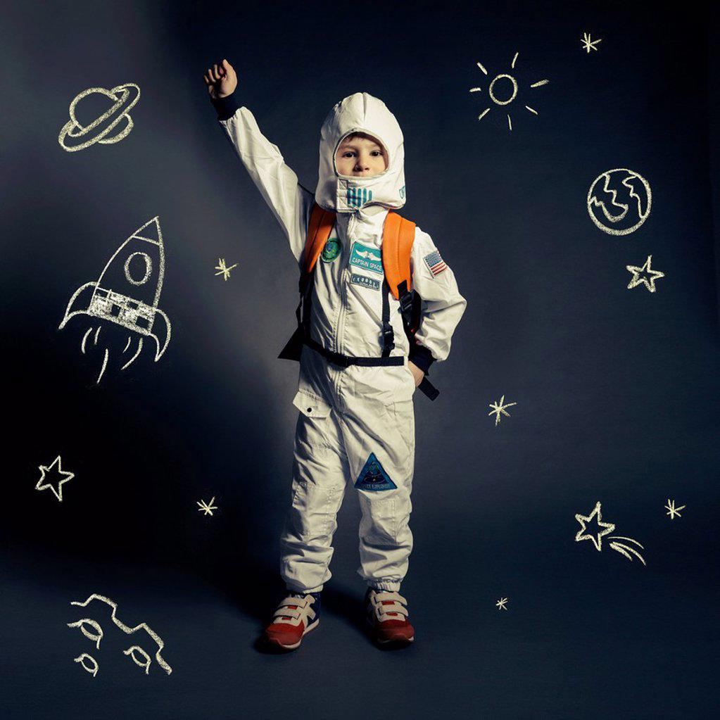 Child with spacesuit orbited by celestial bodies and luminaries