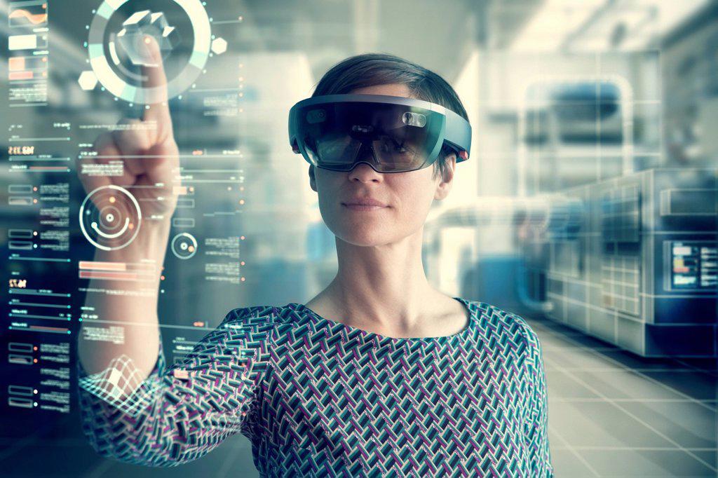 Woman wearing mixed reality smartglasses touching transparent screen