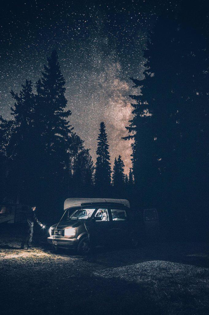 Canada, British Columbia, Chilliwack, man with torch at minivan at night