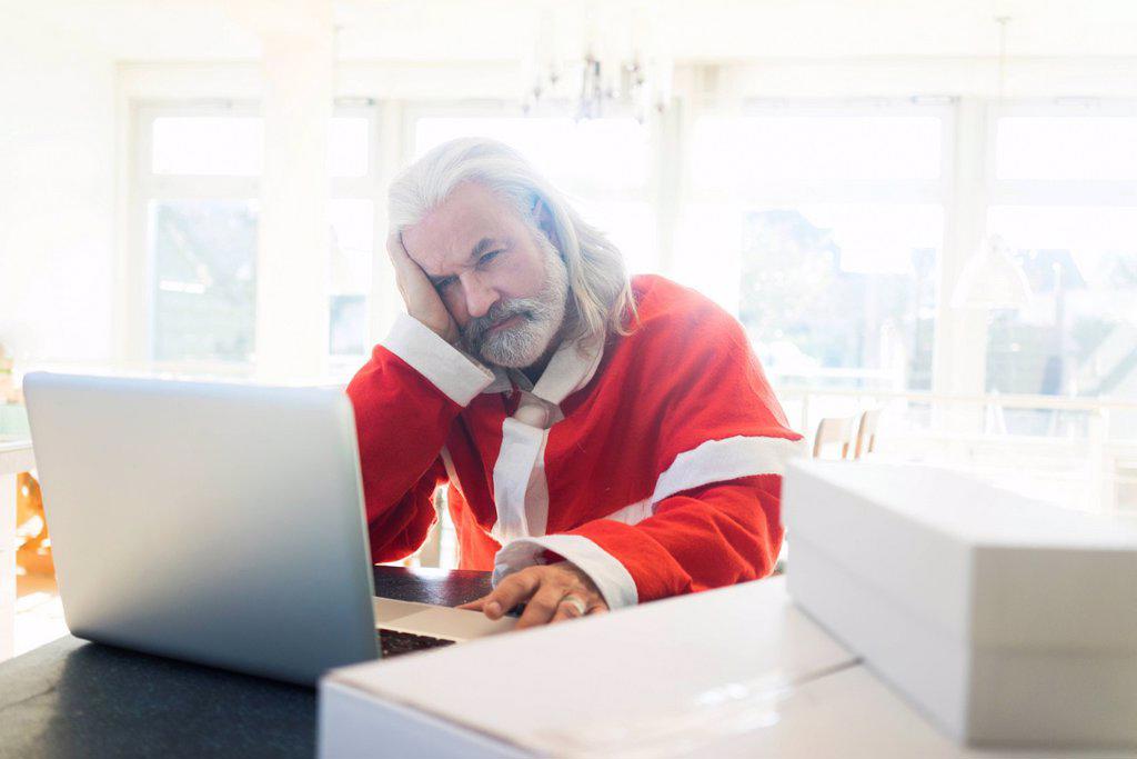 Frustrated Santa using laptop at home