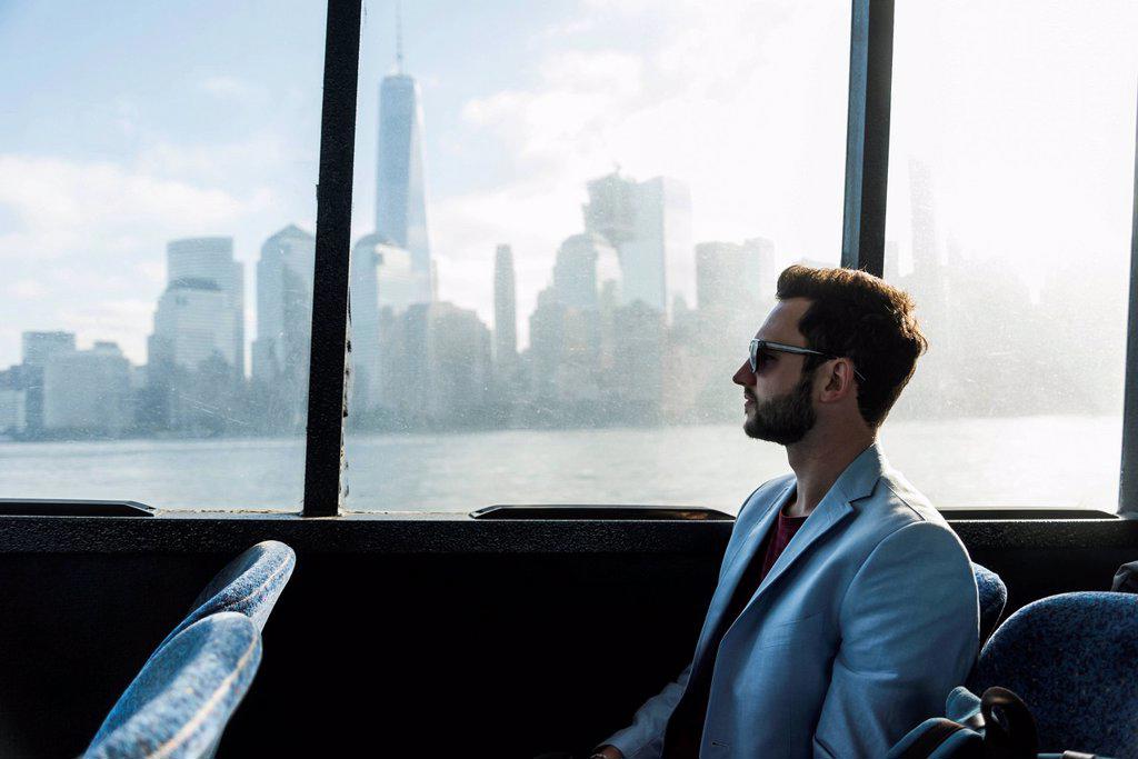 USA,New York City, businessman on passenger deck of a ferry