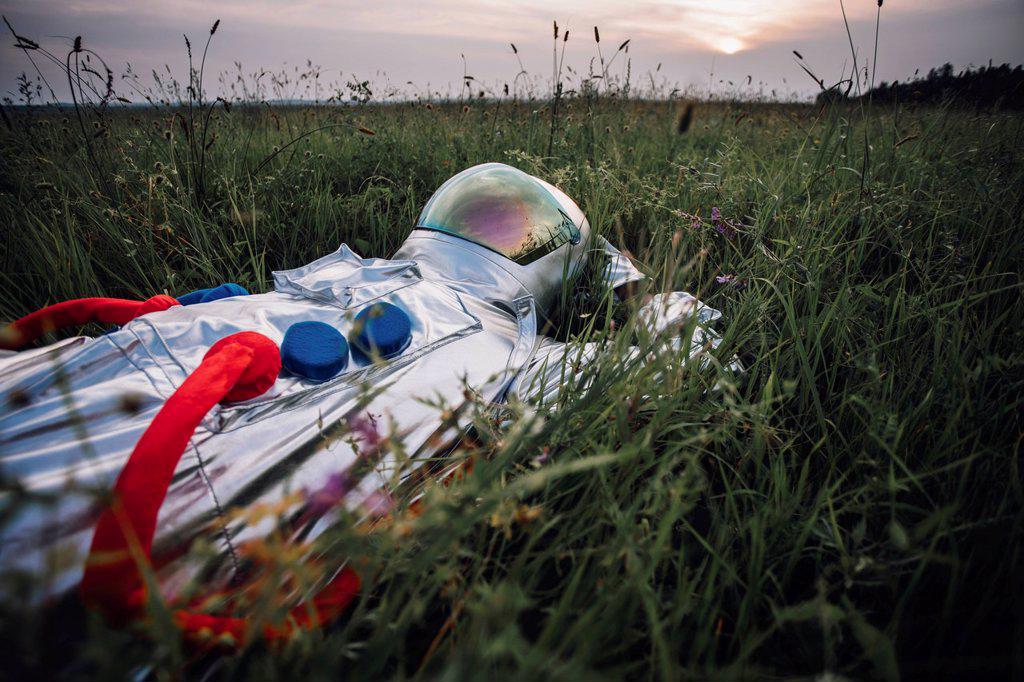 Spaceman exploring nature, relaxing in meadow