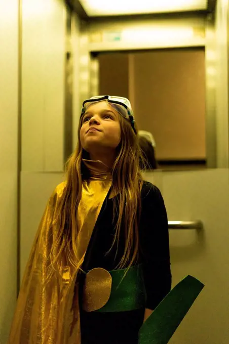 Girl in super heroine costume in elevator looking up