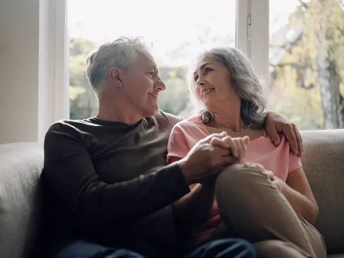 Affectionate senior couple relaxing on couch at home