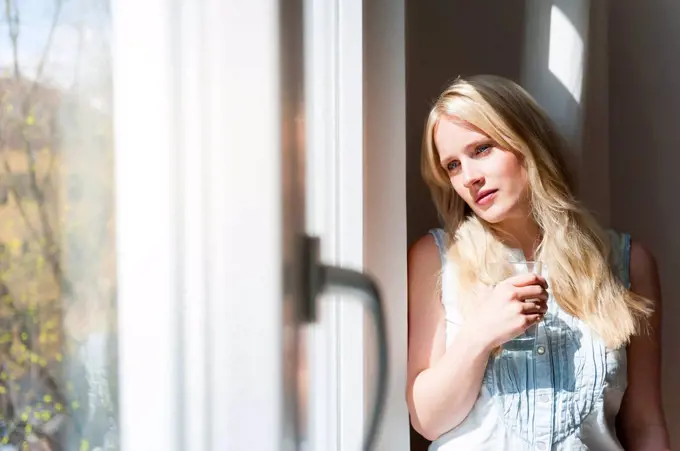 Portrait of serious blond woman looking out of window