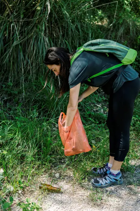 Hiker picking up trash in the woods
