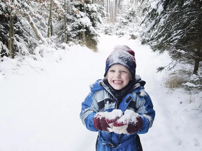 Austria, Boy playing with snow in forest
