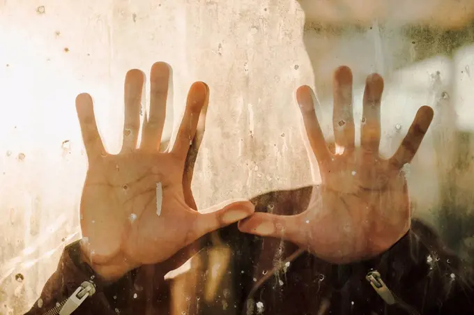 Man's hand touching dirty glass