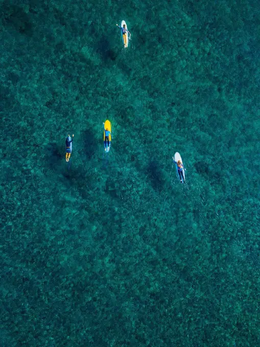 Aerial view of surfers swimming in turquoise waters of Arabian Sea