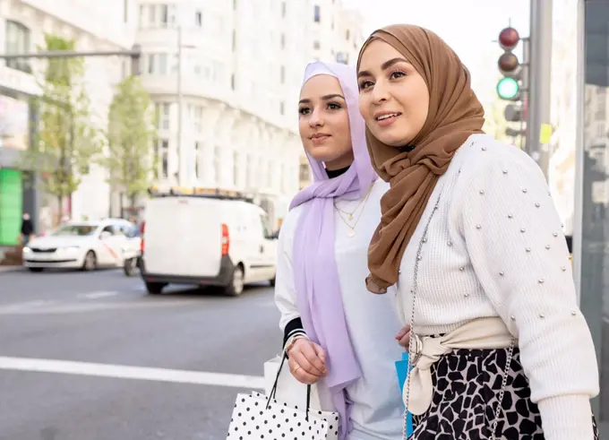 Arab women looking for ride while standing in city