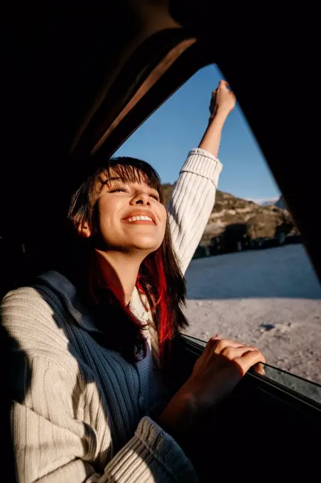 Happy young woman travelling in car