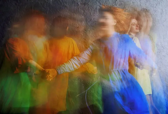 Female friends in colorful dress dancing together