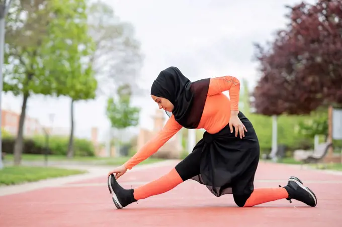 Arab woman stretching in public park