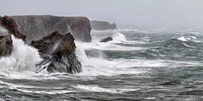 Waves splashing against steep coastal cliffs