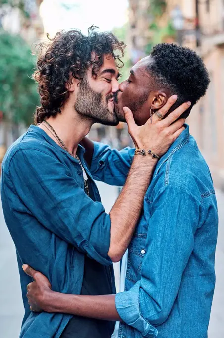 Gay couple with eyes closed kissing each other