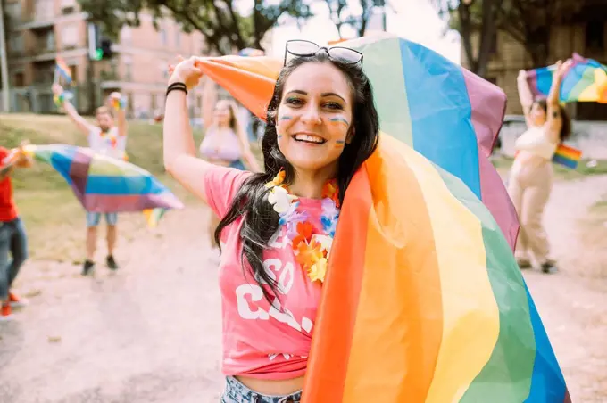 Happy woman with rainbow flag in pride event to protest for equal rights