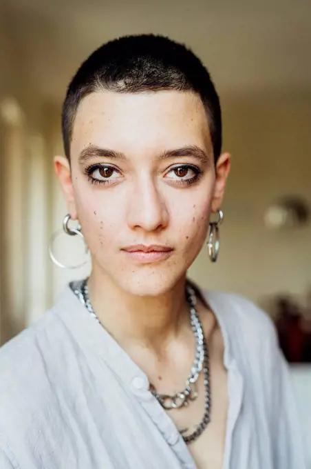 Young woman with short hair wearing jewelry at home