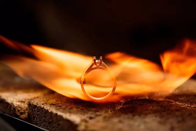 Close-up of burning silver ring in furnace at workshop