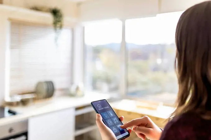 Young woman using smart home application at home