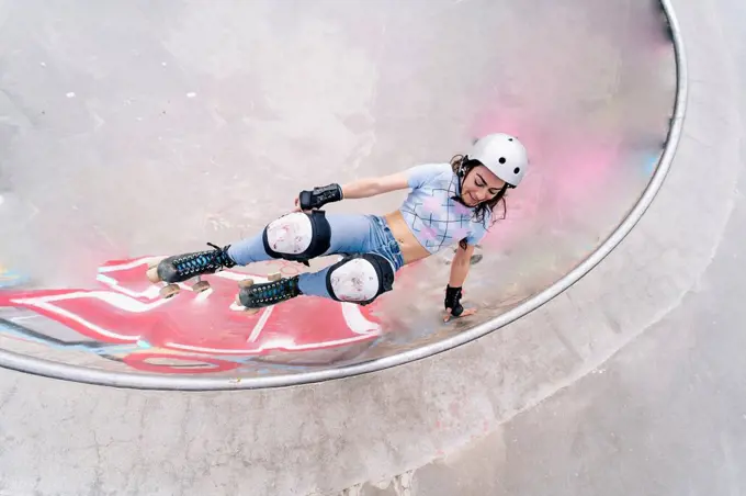 Woman wearing helmet roller skating at park