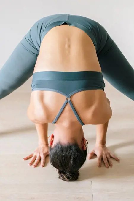 Woman practicing headstand at yoga studio