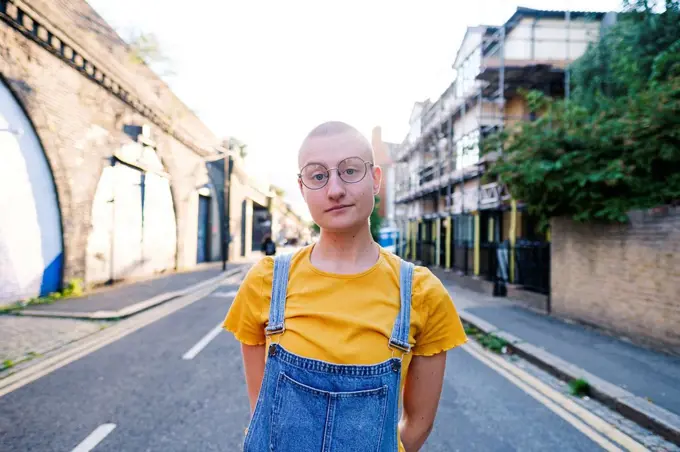 Young transgender person wearing eyeglasses on street
