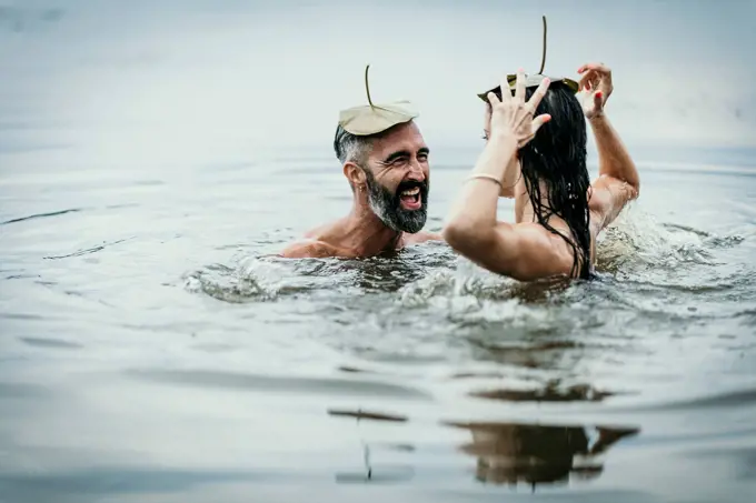 Happy mature man with woman having fun together in lake