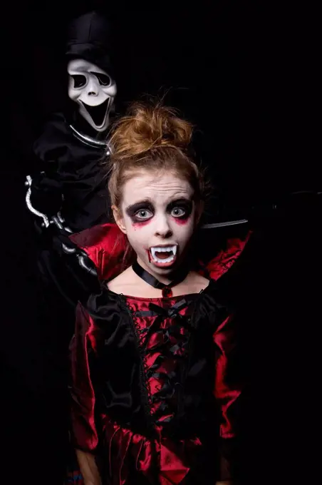 Girl masquarade as vampire and boy wearing Scream mask