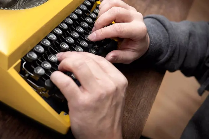 Hands typing on old typewriter